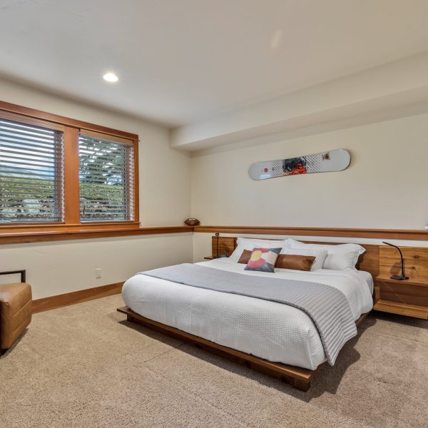 a bedroom with a large bed and a snowboard on the wall