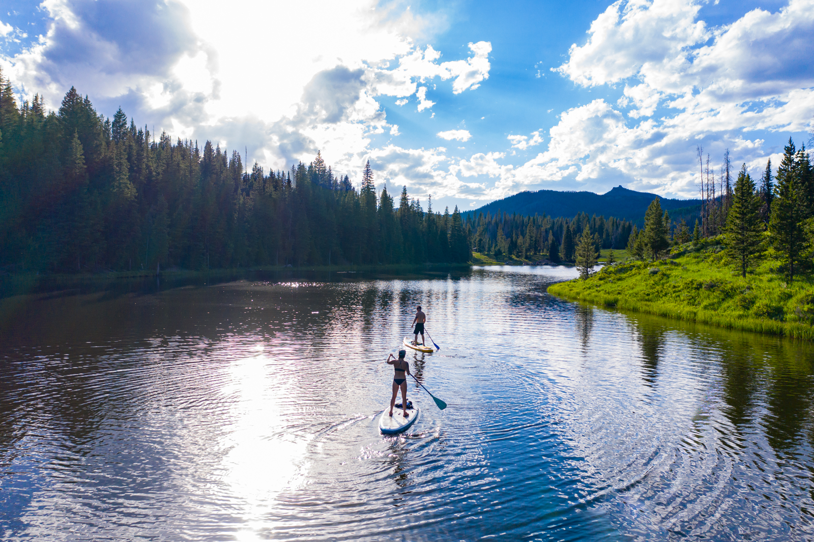 Couple paddle boarding down the Yampa River in Steamboat Springs, Colorado
