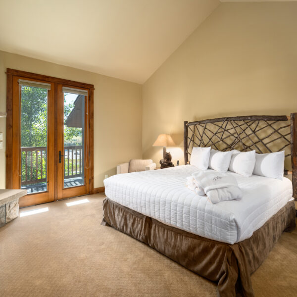 a private bedroom with porch and large bed with light linens