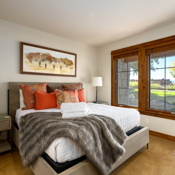a western bedroom with a large bed and red western pillows