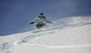 Woman Snowboarding down ski slope