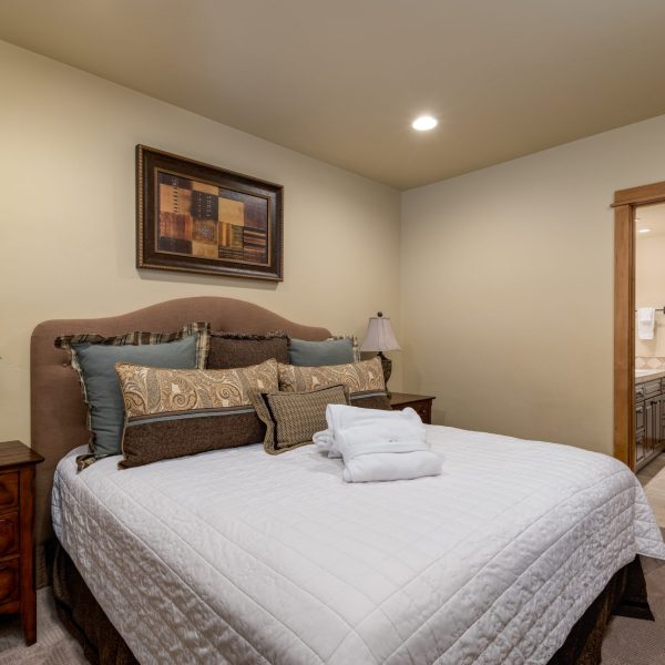 a bedroom with a large bed and a picture on the wall above it